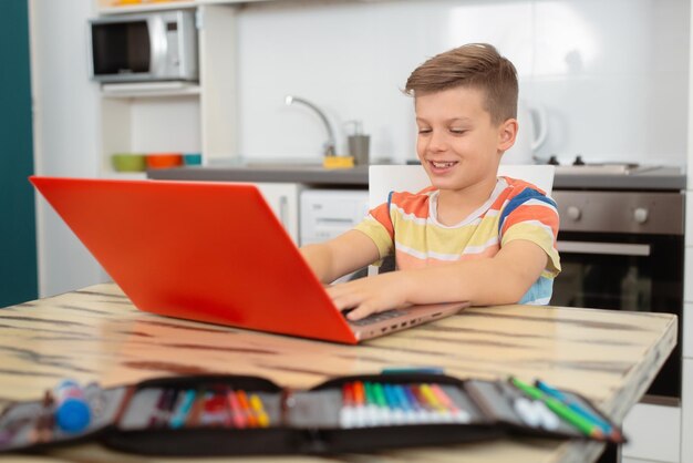 Retour à l'école Petit garçon à l'aide de son ordinateur portable