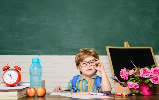 Retour à l'école premier jour d'école enfant dans la salle de classe avec tableau noir sur fond enfant de