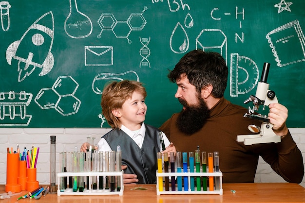 Retour à l'école science et éducation pour élève enseignant aidant un jeune garçon avec une leçon joyeuse ...