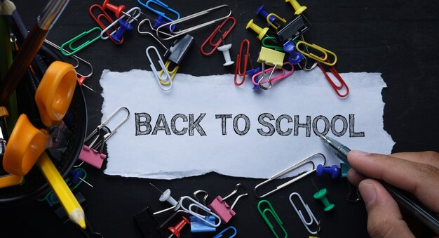 Photo retour à l'école tex. papier déchiré et fournitures scolaires sur tableau noir