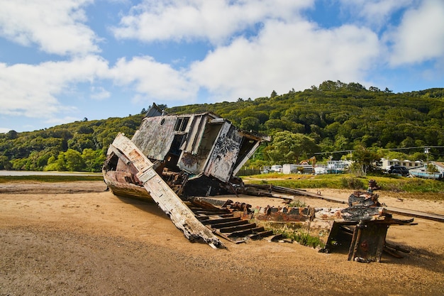 Retour de l'épave sur la plage de sable en train de s'effondrer