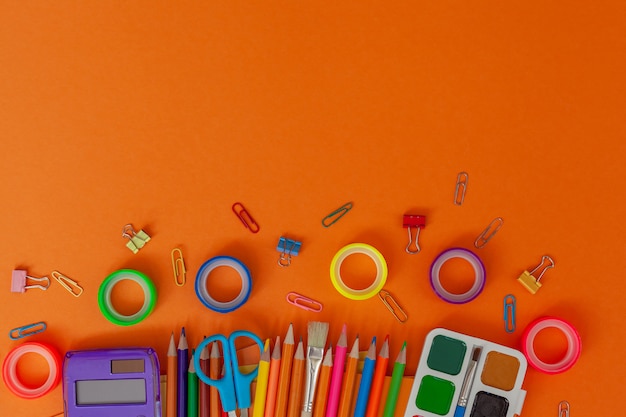 Retour à fond d'école avec des fournitures scolaires sur la table orange. Vue d'en haut