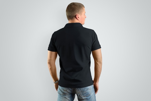 Retour Polo noir Mockup sur un modèle masculin pour un exemple de conception. Homme isolé sur fond gris.