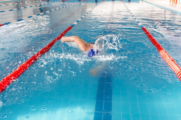 Un retraité de 70 ans se repose en train de nager dans la piscine à l'eau claire et bleue de l'hôtel