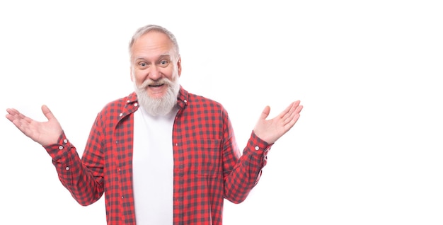 Un retraité aux cheveux gris souriant d'un an avec une barbe et une moustache de manière décontractée étend son