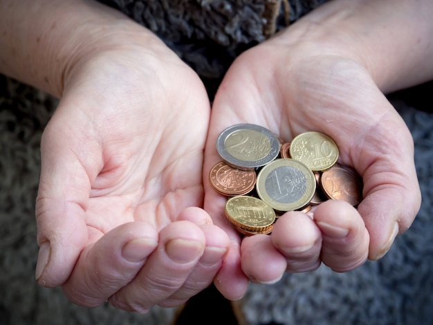 Retraité avec des pièces en euros en main