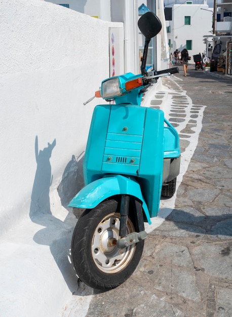 Photo retro blue scooter honda dans la rue de la vieille ville chora mykonos grèce