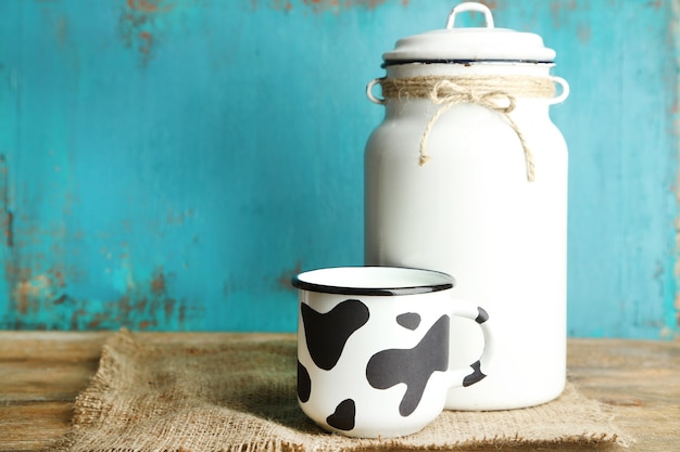 Retro peut pour le lait et la tasse de lait sur la table en bois