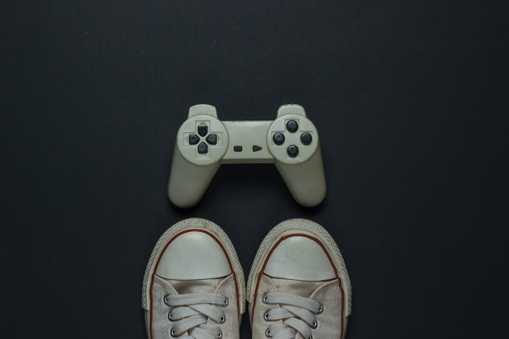 Photo rétro vieilles baskets et manette de jeu sur fond noir. années 80. vue de dessus