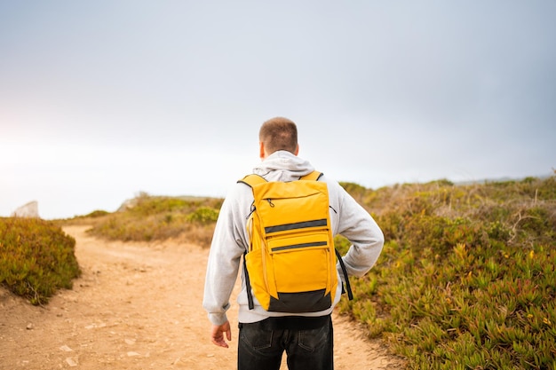 Rétroviseur jeune homme voyageur avec sac à dos jaune