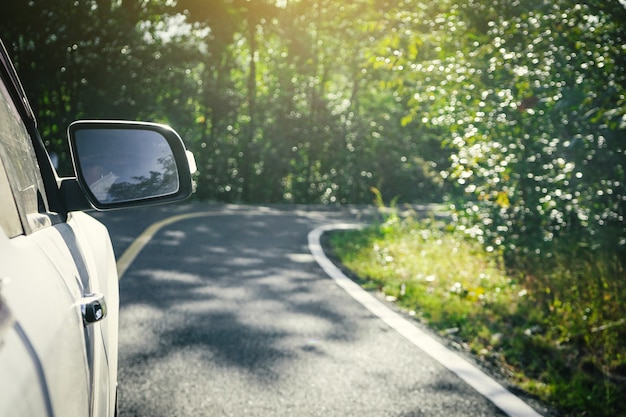 Le rétroviseur d'une voiture avec la rue de la nature.