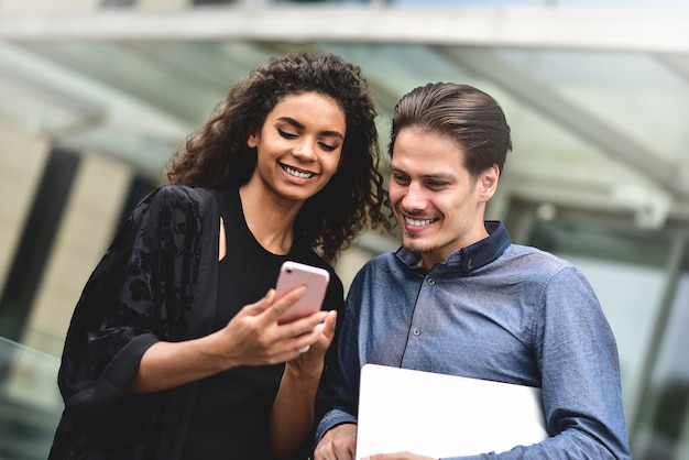 réunion d'affaires homme et femme discutant du travail et regardant l'écran du smartphone travailler ensemble