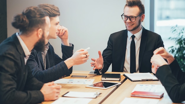 Réunion d'affaires. Jeune chef de projet masculin donnant des instructions à l'équipe professionnelle.