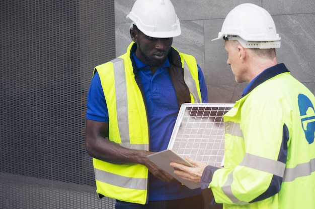 Photo réunion d'équipe d'ingénieurs en énergie renouvelable travaillant sur un concept innovant de batterie de panneau solaire plus efficace, résolvant les problèmes