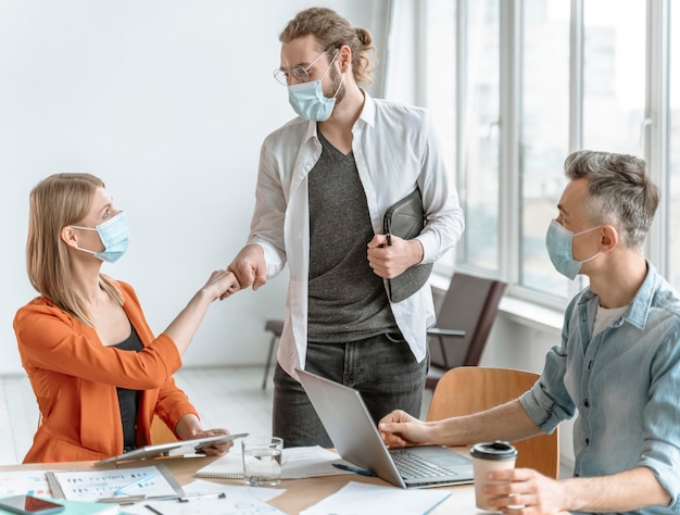 Photo réunion de gens d & # 39; affaires au bureau portant des masques