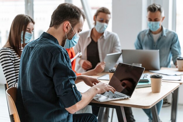 Photo réunion de gens d & # 39; affaires au bureau portant des masques