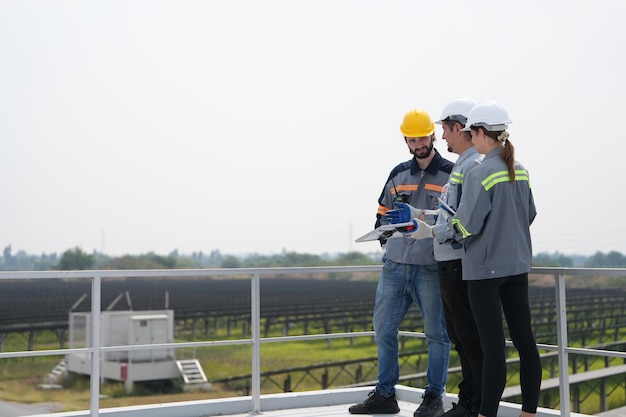 Réunion d'ingénieurs pour vérifier le panneau solaire sur le toit d'une ferme solaire avec un système de stockage d'énergie exploité par Super Energy Corporation Des spécialistes se sont réunis pour des tests en extérieur Module de cellules photovoltaïques