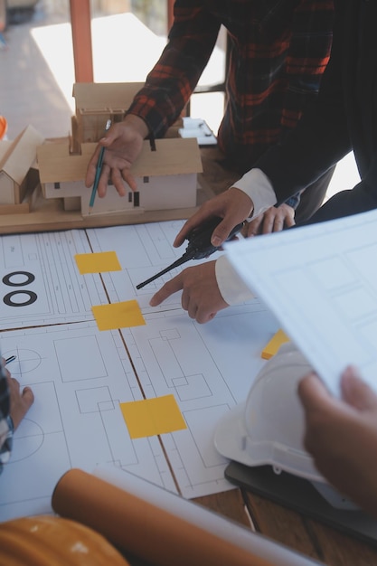 Photo réunion de travail d'équipe d'ingénieurs dessin travaillant sur la réunion de plan directeur pour le projet travaillant avec un partenaire sur la construction de modèles et les outils d'ingénierie sur le site de travail concept de construction et de structure