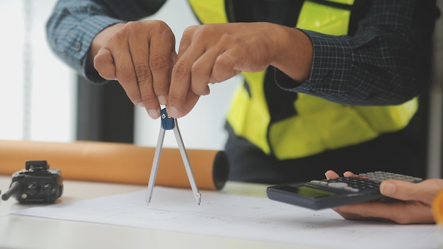 Photo réunion de travail d'équipe d'ingénieurs dessin travaillant sur une réunion de plan pour le projet travaillant avec un partenaire sur la construction de modèles et les outils d'ingénierie sur le chantier concept de construction et de structure