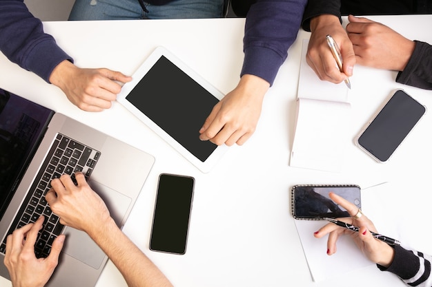 Réunion de travail d'équipe sur une table, avec les mains, vue de dessus