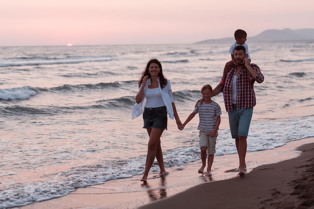 Réunions de famille et socialisation sur la plage au coucher du soleil. La famille se promène le long de la plage de sable. Mise au point sélective. Photo de haute qualité