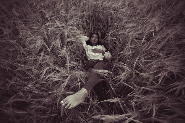 Rêvant dans un champ de blé une belle jeune femme adulte