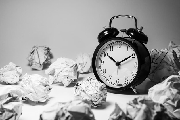 Réveil avec boules de papier froissé. Concept d'idée de synchronisation et de réflexion.