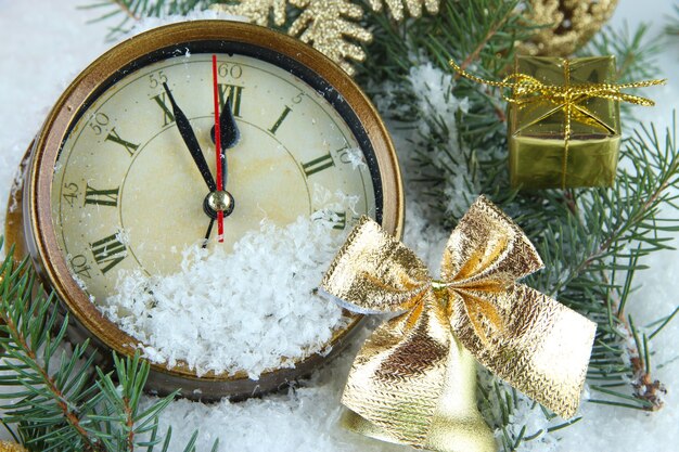 Réveil avec des branches de sapin et des décorations de Noël sous la neige se bouchent