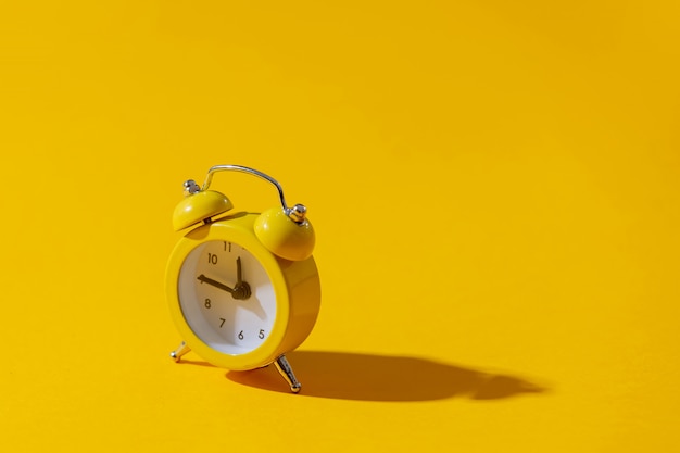 Photo réveil avec deux cloches sur fond jaune