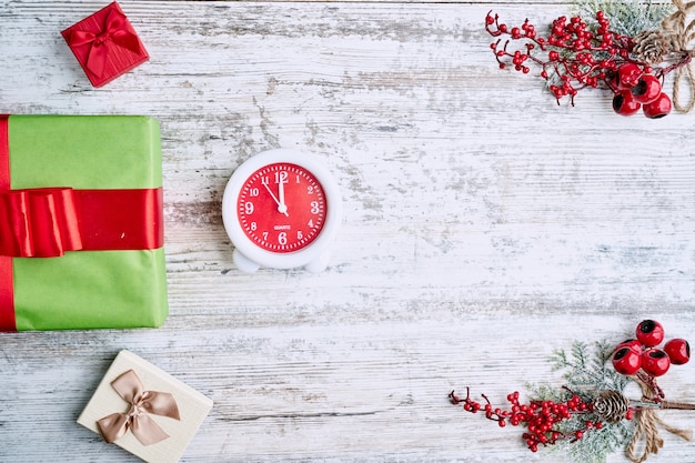 Réveil sur fond sur une table en bois décorée d'une guirlande et de boules de Noël rouges pour le nouvel an ou Noël. Espace de copie