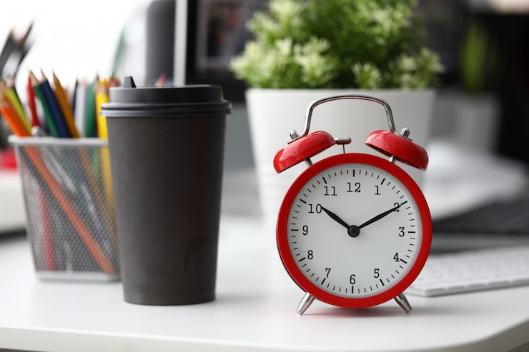 Photo réveil rouge avec une tasse de café en papier noir