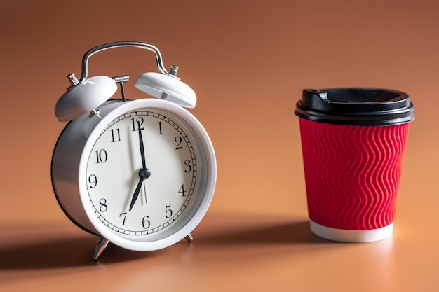 Réveil et tasse de café jetable en papier