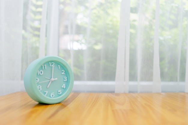 Réveil vert clair posé sur la table de la chambre