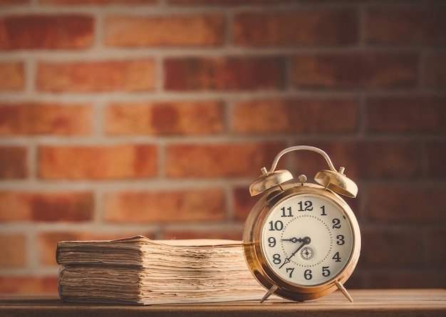 réveil vintage et vieux livres sur une table en bois