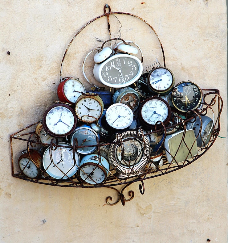 Photo des réveils d'époque à l'intérieur d'un porte-à-faux en fer monté sur le mur