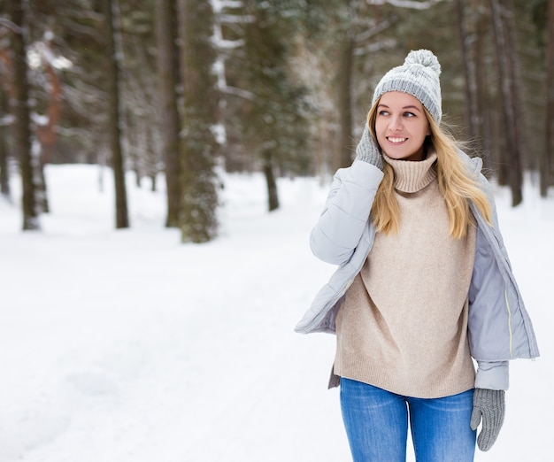 Rêver de belle jeune femme marchant dans la forêt d'hiver