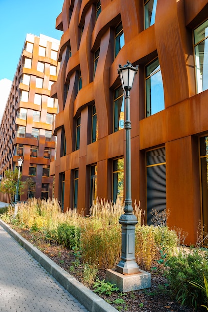 Un réverbère devant un immeuble à la façade en métal marron.