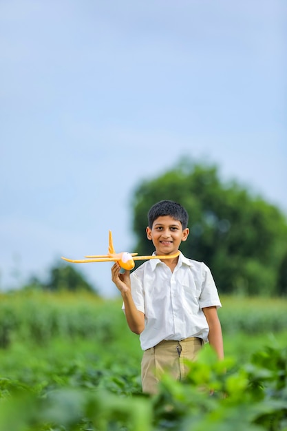 Rêves de vol! indien, enfant, jouer, à, jouet, avion, à, champ vert