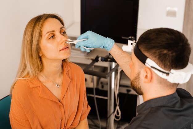 Rhinoscopie du nez de la femme Consultation avec un médecin L'oto-rhino-laryngologiste examine le nez de la fille avant la procédure d'endoscopie du nez