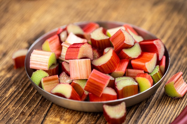 Rhubarbe hachée sur une vieille table en bois gros plan