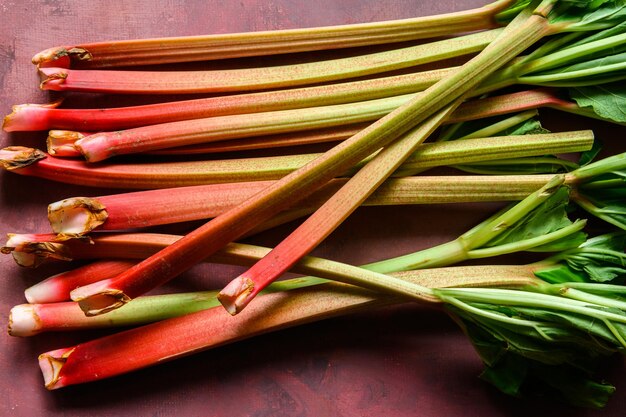 Photo rhubarbes vertes et rouges mûres fraîches sur une table rustique de bourgogne 2