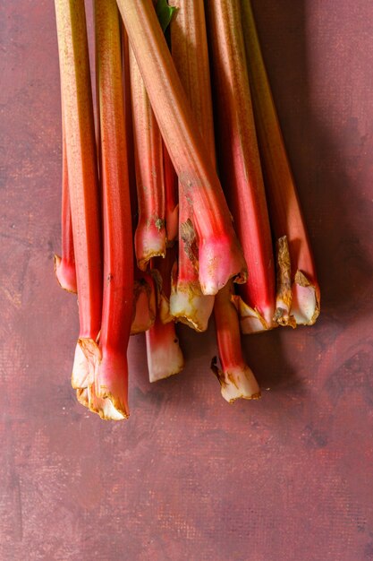 Photo rhubarbes vertes et rouges mûres fraîches sur une table rustique de bourgogne 3