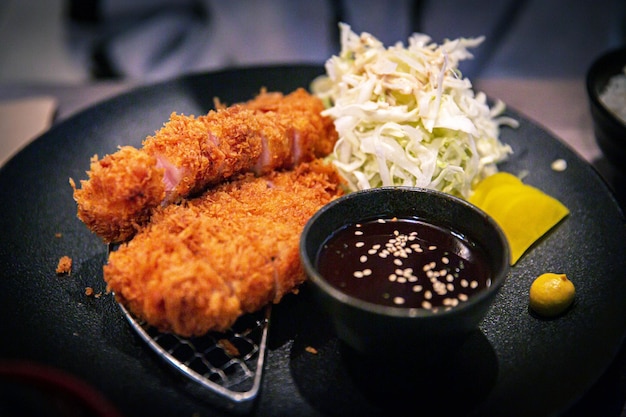 Photo ribeye tonkatsu de porc frit traditionnel japonais satisfaisant coupé avec des cornichons et du chou servi dans un