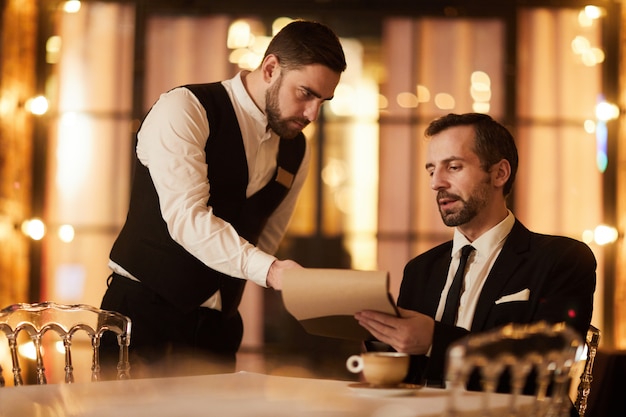 Riche homme commandant de la nourriture au restaurant