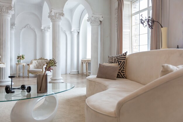 Riche intérieur luxueux d'une chambre confortable avec des meubles modernes et élégants et un piano à queue, décoré de colonnes baroques et de stuc sur les murs