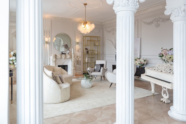 Riche intérieur luxueux d'une chambre confortable avec des meubles modernes et élégants et un piano à queue, décoré de colonnes baroques et de stuc sur les murs