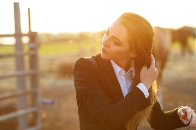 Rider femme avec fouet au coucher du soleil