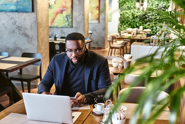 Rien ne peut battre un dur labeur, un homme d'affaires afro-américain travaille avec son ordinateur portable tout en se reposant