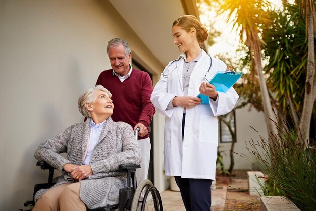 Rien ne la rend plus heureuse que de laisser sortir un patient en bonne santé Photo d'un couple de personnes âgées et d'une infirmière à l'extérieur d'une maison de retraite