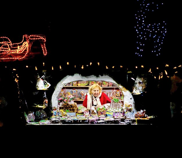 Riga, Lettonie - 24 décembre 2015 : Femme vendant l'une des friandises sucrées les plus traditionnelles qui sont des pains d'épice photographiés au Marché de Noël de Riga, Lettonie.